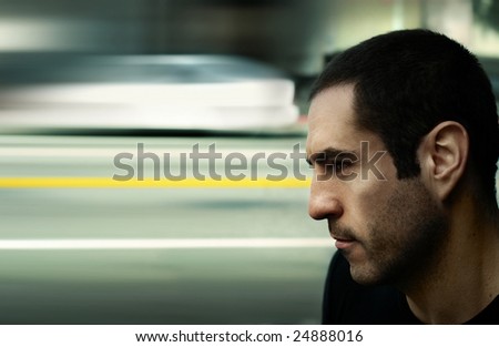 Dramatic edgy stylized cinematic portrait of a serious man with blurred city street and traffic in background