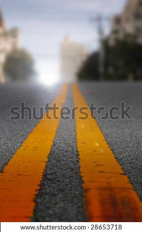 Two yellow road lines fading off into distance (shallow depth of field)