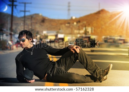 Conceptual photo of a trendy man laying in middle of road split between night and day