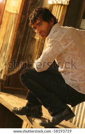 Young male model in golden sunlight turning back toward camera