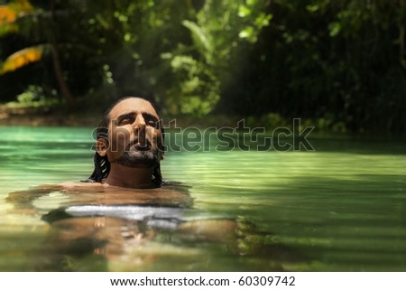 Portrait of a man floating in tropical emerald waters relaxing