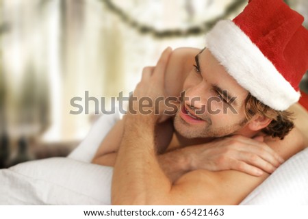 Cute young man in Santa cap laughing and smiling