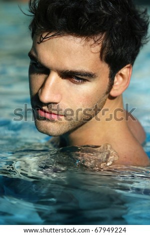 Portrait of a handsome young man in swimming pool
