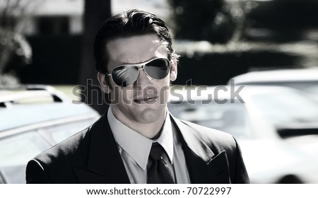 Stylized portrait of a young man in suite and sunglasses