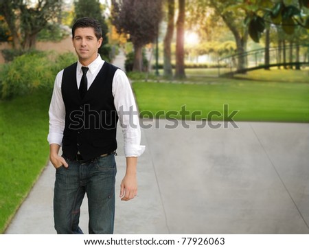Portrait of a young man in tie and white shirt standing in beautiful outdoor park setting