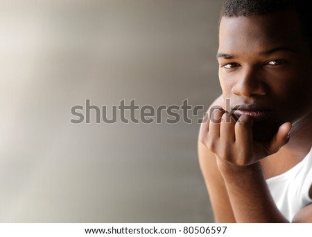 Portrait of a young black man thinking against neutral modern background with copy space
