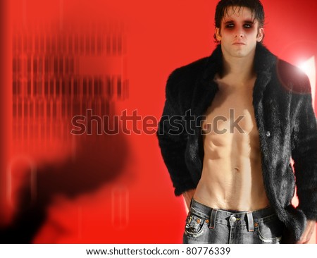Fashion portrait of edgy male model wearing eye makeup in fur against red background