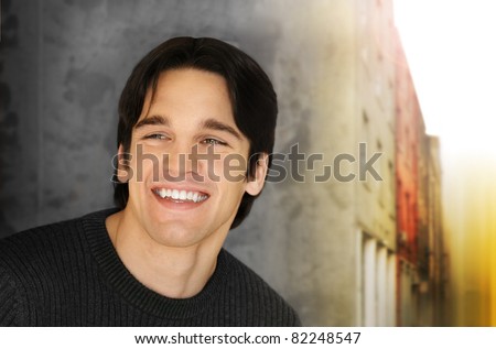 Portrait of a handsome young man with big smile against cool styled outdoor background