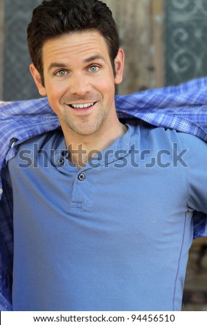 Fun portrait of young guy smiling wearing blue