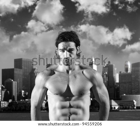 Fine art black and white portrait of a sexy muscular model making expression against background of dramatic sky and city