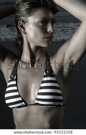 Dramatic stylized fashion portrait of beautiful sexy young woman in bikini with water drops on her skin