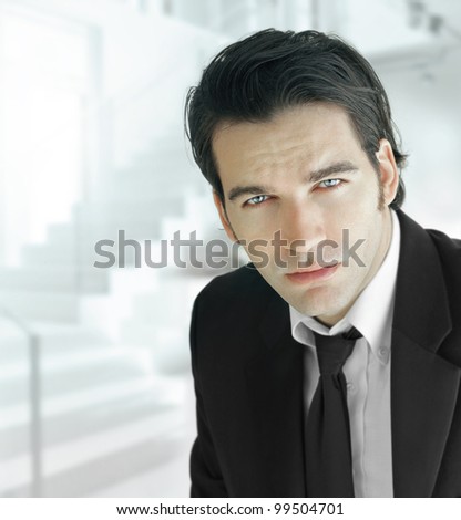 Portrait of a handsome businessman in elegant suit and tie against modern office background