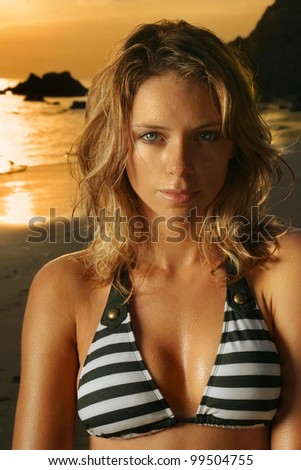 Fashion stylized portrait of a beautiful blonde female model in bikini on the beach at sunset