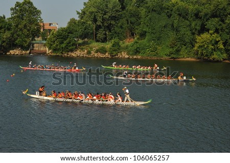 RICHMOND, VIRGINIA/USA - JULY 30, 2011: Dragon Boat racers heading down the James RIver in Richmond, Virginia during the Dragon Boat Festival held at Rockett\'s Landing on July 30, 2011.