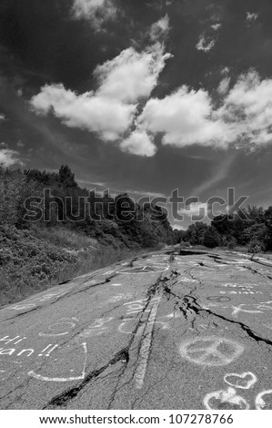 Black and white image of the cracked and buckled highway of a ghost town in Centralia, Pennsylvania.  The result of an underground mine fire that has been burning since 1962.
