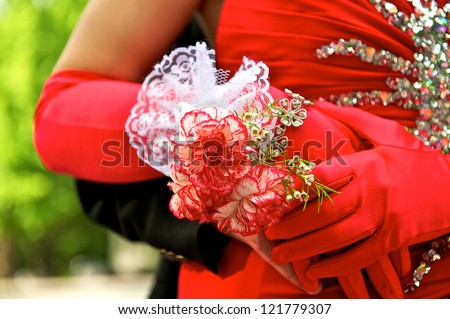 Beautiful prom couple showing off the her elegant gloves and corsage.