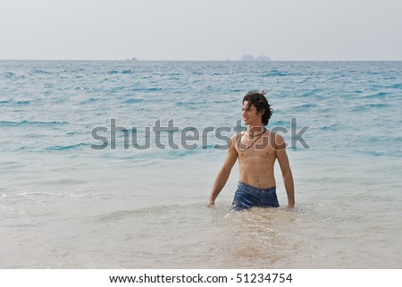 Athletic and muscular man in the surf of the Atlantic Ocean.
