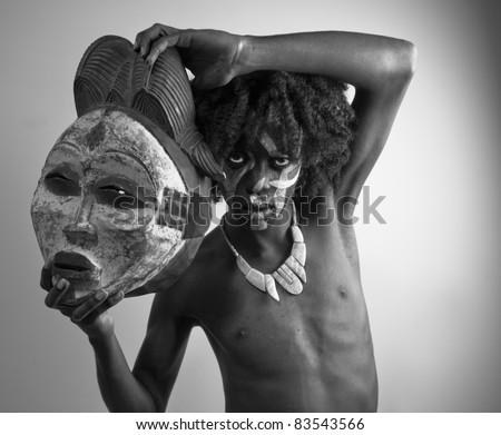 Black and white image of an aboriginal man holding an authentic African mask.