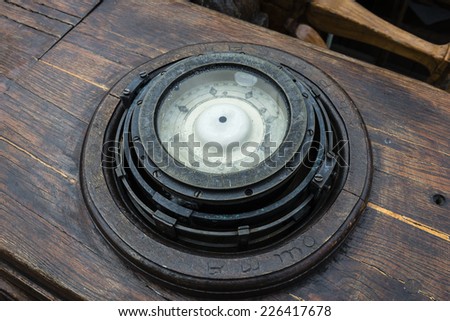Ships compass on the deck of an old wooden sailing ship.