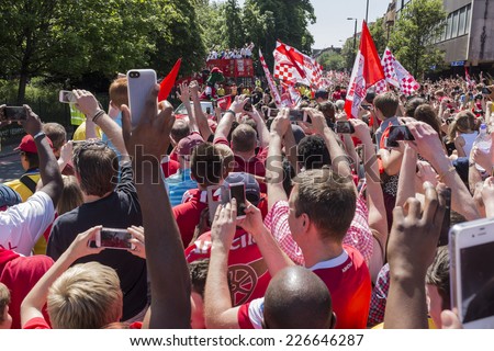LONDON, UK - MAY 18, 2014 : Winners of the 2014 FA Cup, Arsenal Football Club parade their trophy around the streets of Islington north London on a red open top bus after defeating Hull City.