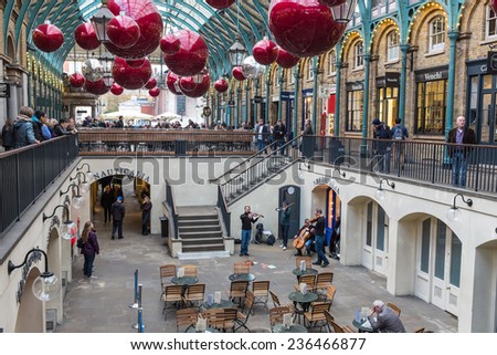 LONDON, UK - NOVEMBER 5, 2014 : Musical string band busking under the lights and Christmas decorations hanging from the roof in Apple Market at Covent Garden in central London.