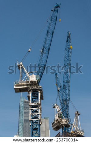 LONDON, UK - OCTOBER 19, 2014 : Construction cranes at work constructing high rise buildings in the city of London.