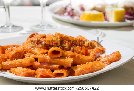 Amatriciana: traditional italian pasta with pork cheek and tomato sauce served with grated cheese