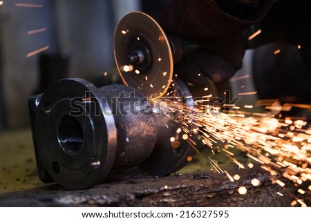 Electric wheel grinding on steel structure in factory