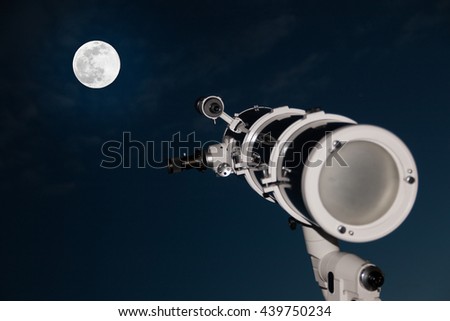 Astronomical telescope over dark sky with the moon in the night