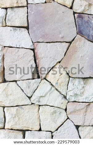 Multi-colored and multi-sized, pale rocks wall grunge texture background.