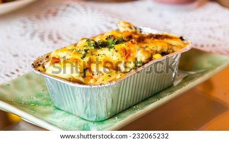 Lasagne ready meal in foil container on the table