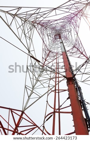 red and white color antenna repeater tower from bottom view on white sky