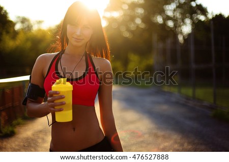 healthy fitness girl with protein shake. sport and work out girl in sunny day