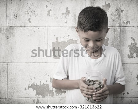 Young boy counting his saved coins and thinking about what he can buy