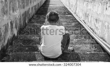 scared and alone, young homeless Asian child who is at high risk of bing bullied, trafficked and abused
