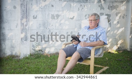 Older man reading in the garden