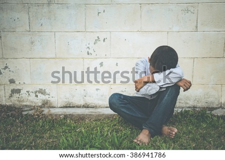scared and alone, young homeless Asian child who is at high risk of being bullied, trafficked and abused, selective focus