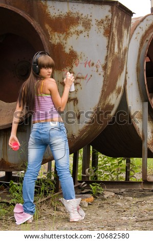 beauty girl in headphones painting on constructions