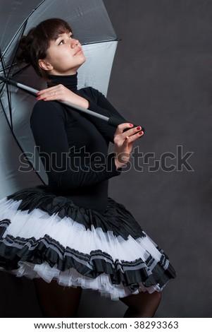 beauty ballerina with silver umbrella on grey background