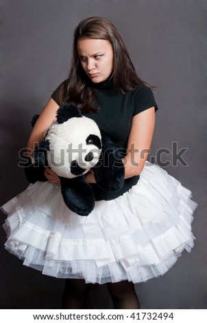 ballerina sulking with panda in white shirt on grey background