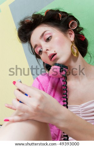 beauty girl pink phone call and paint her nails on color wall background