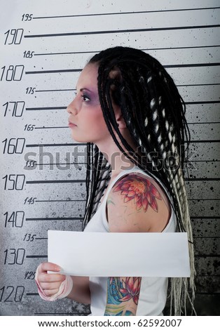 white girl in prison with injuries and body art on her arm on ruler background