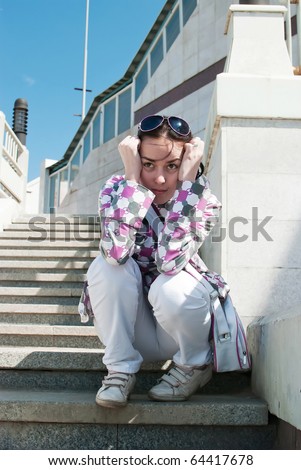 beauty and sad girl sit on stairs on the wall and stairway background