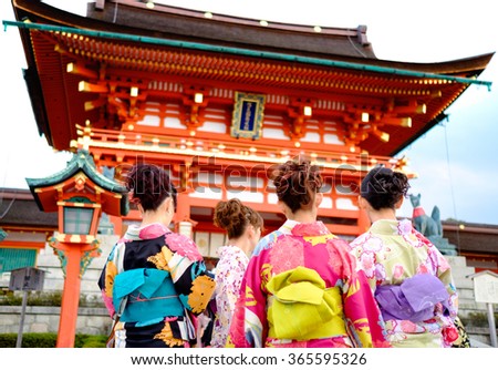 Young girl wearing Japanese kimono standing in front of japanese Temple in Kyoto, Japan.
