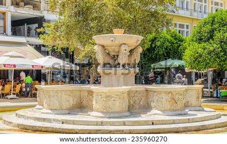 HERAKLION, CRETE, GREECE - AUGUST 11, 2013: Old Morosini Fountain and cafes around it at Heraklion town on Crete island, Greece.