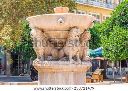 HERAKLION, CRETE, GREECE - AUGUST 11, 2013: Old Morosini Fountain and cafes around it at Heraklion town on Crete island, Greece.