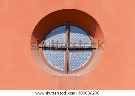 Round window in pink wall of old historic building