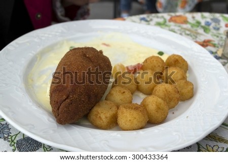 Pork cutlet and potatoes served on plate in restaurant