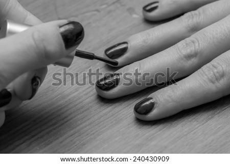 Close up from a woman polishing her nails in black and white