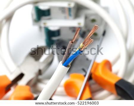 stripped wire in front of electric tools and equipment, shallow depth of field
